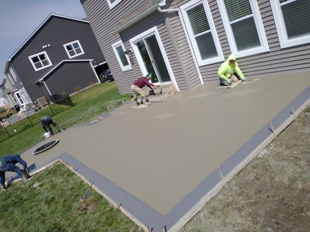 Crew finishing a fresh concrete patio pour