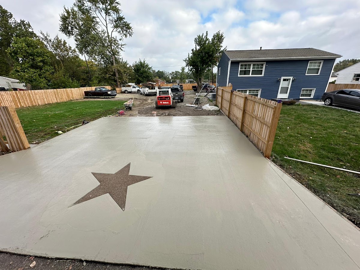 Fresh driveway pour with an exposed-aggregate star stamped into the concrete